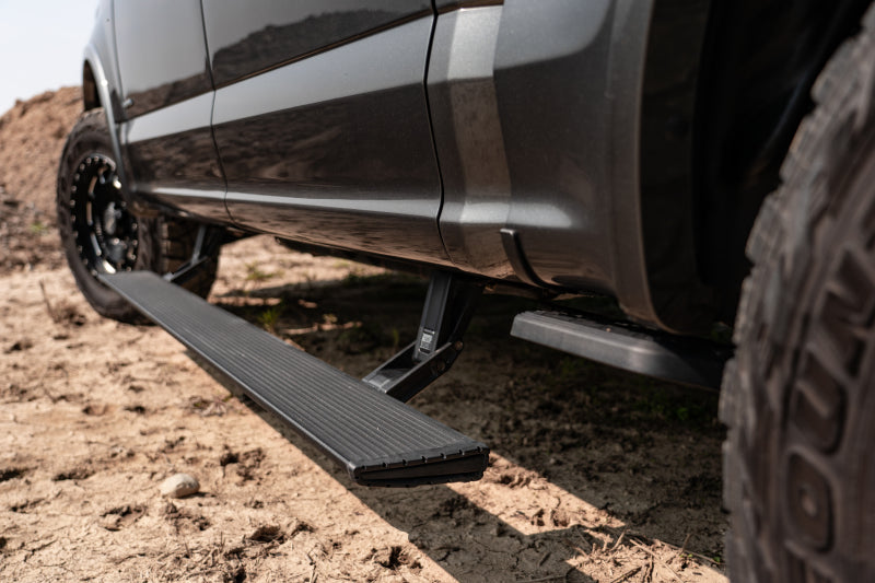 AMP Research 20-23 Jeep Gladiator (Launch/Overlnd/Rubicon/Sport/Sport S) PowerStep Xtreme - Black close-up in off-road terrain.