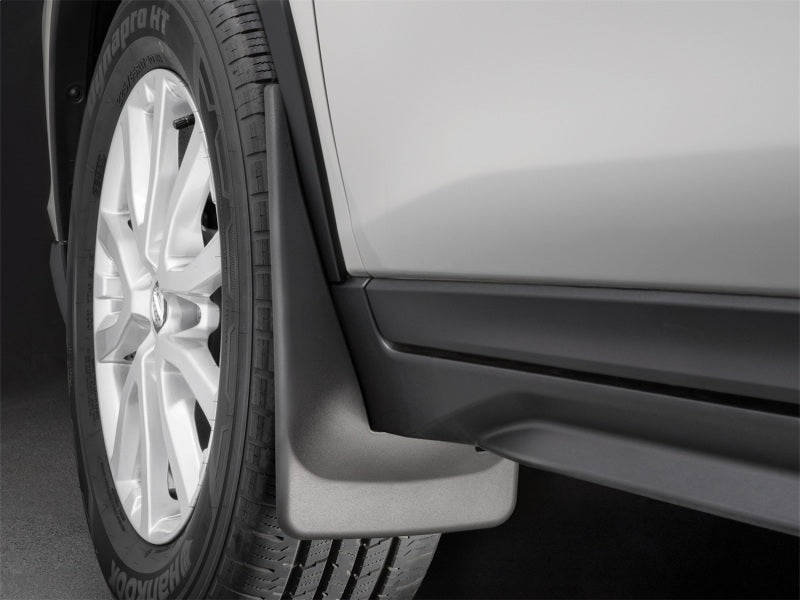 WeatherTech 2014+ Nissan Rogue Front No Drill Mudflaps - Black installed on vehicle tire