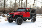 Fishbone Offroad 97-06 Jeep Wrangler TJ Steel Tube Fenders Front 3In Flare - Blk Textured Powdercoat in snowy outdoor setting