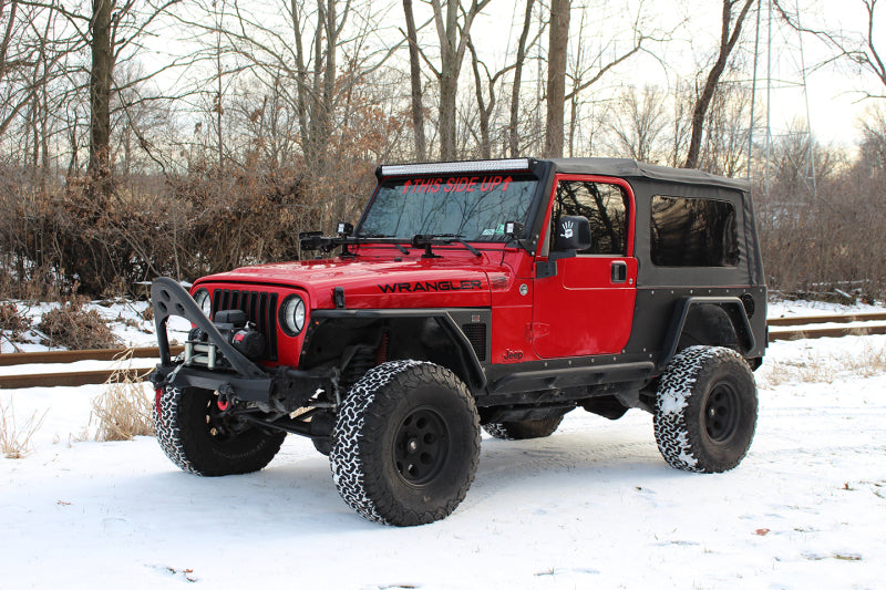 Fishbone Offroad 97-06 Jeep Wrangler TJ Steel Tube Fenders Front 3In Flare - Blk Textured Powdercoat in snowy outdoor setting