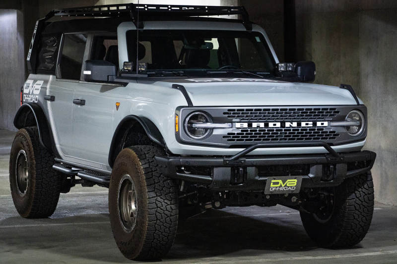 DV8 Offroad 21-22 Ford Bronco Factory Front Bumper Licence Relocation Bracket - Front on a modified Bronco in a garage.