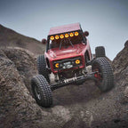 KC HiLiTES Gravity Titan LED Light Bar - 39in. (6-Light) on offroad truck climbing rocks.