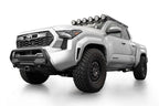Addictive Desert Designs2024+ Toyota Tacoma Stealth Center Mount Winch Front Bumper w/ Top Hoop with offroad tires and lighting.