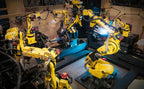 Automated robotic arms working in a manufacturing facility.