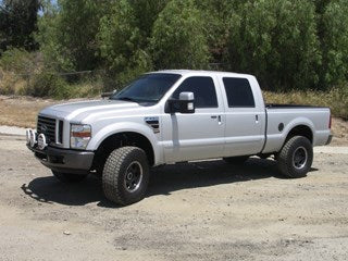 Silver off-road truck with lifted suspension and aftermarket wheels, ideal for performance offroad upgrades.