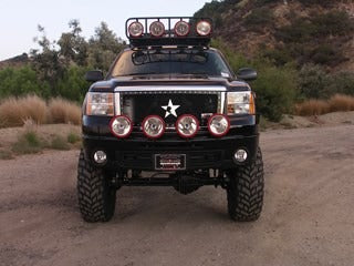 Offroad truck with aftermarket lights and large tires, ready for tough terrains.